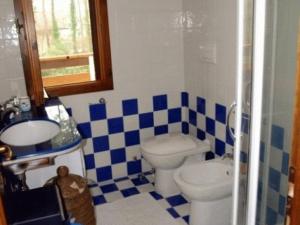 a blue and white bathroom with a toilet and a sink at Lignano Pineta very nice in Lignano Sabbiadoro