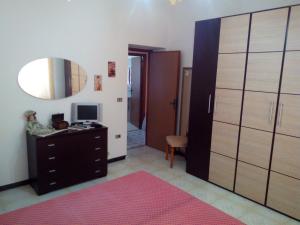 - une chambre avec une commode et un miroir dans l'établissement Appartamento Gianluca, à SantʼAntìoco