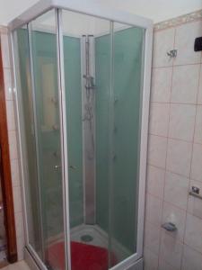 La salle de bains est pourvue d'une douche avec une porte en verre. dans l'établissement Appartamento Gianluca, à SantʼAntìoco