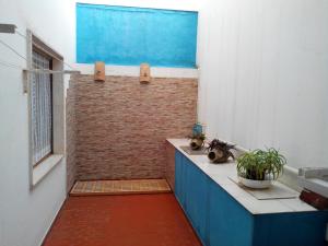 La salle de bains est pourvue d'une douche et d'un mur en briques. dans l'établissement Appartamento Gianluca, à SantʼAntìoco