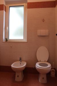 ein Badezimmer mit Toilette und Waschbecken und einem Fenster in der Unterkunft Villa I Gemelli in Vieste