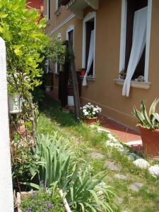 einen Garten mit Pflanzen und Blumen vor einem Gebäude in der Unterkunft Perla B&b in Lido di Venezia