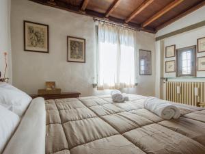 フィレンツェにあるMamo Florence - Vasari Apartmentのベッドルーム1室(大型ベッド1台、タオル付)