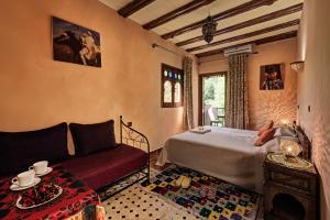 a bedroom with a bed and a couch at Riad Oussagou in Imlil