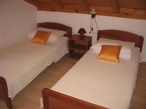 a bedroom with two beds and a table with a lamp at Apartments Darinka in Skradin