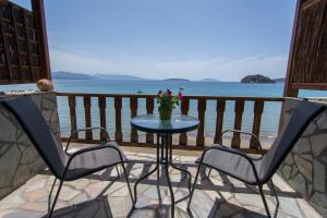 a table and chairs on a balcony with the ocean at Poseidon Apartments in Tolo