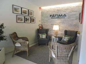 a waiting room with chairs and a table and a sign at Fátima GuestHouse in Fátima
