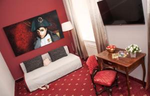 a small room with a bed and a painting of a soldier at Urban Stay Salzburg City in Salzburg