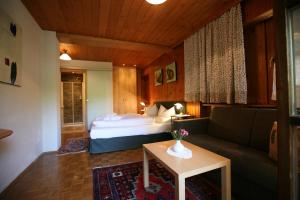 a bedroom with a bed and a couch and a table at Bio-Hotel Saladina in Gaschurn