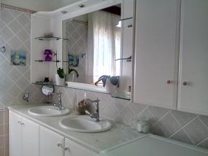 a bathroom with two sinks and a mirror at Villa Rose Garden in Agios Ioannis +33 photos