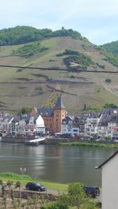 a town next to a body of water with houses at Ferienwohnung-Hallebach in Zell an der Mosel