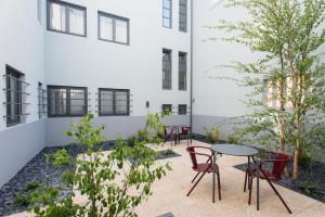 a courtyard with chairs and a table in front of a building at Oporto Serviced Apartments - Alvares Cabral in Porto