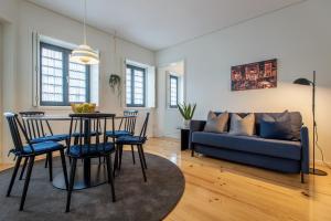 ein Wohnzimmer mit einem Tisch, Stühlen und einem Sofa in der Unterkunft Oporto Serviced Apartments - Alvares Cabral in Porto