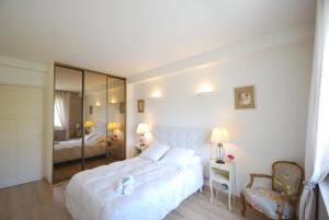 カンヌにある2 Chambres Palais Justiniaのベッドルーム(大きな白いベッド1台、鏡付)