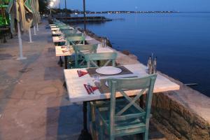 a row of tables and chairs sitting next to the water at Assos Zeyti̇n Han Special Class Hotel in Sokakagzi