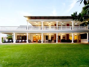 a large white house with a green lawn at OR Tambo Guest House in Kempton Park