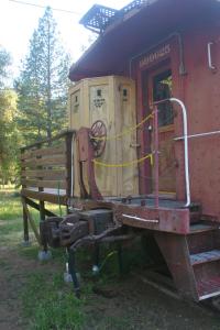 une vieille voiture de train est garée dans un champ dans l'établissement Little Red Caboose, à Oakhurst