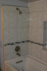 a shower with a shower head and a sink at Little Red Caboose in Oakhurst