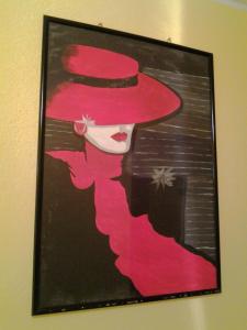 a picture of a woman in a red hat on a wall at Hotel Su Giudeu in Chia