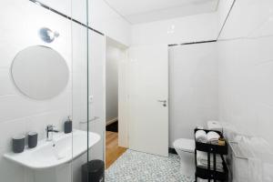 a white bathroom with a sink and a toilet at Oporto Serviced Apartments - Alvares Cabral in Porto