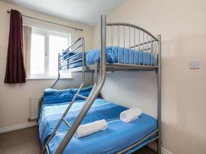 - une chambre avec des lits superposés avec des draps bleus et une fenêtre dans l'établissement My-Places Corporate Serviced Accommodation, à Manchester