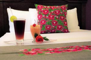 - une table avec une boisson et une bougie sur un lit dans l'établissement Hotel Plaza Campeche, à Campeche