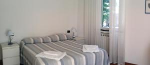 a bedroom with a bed with towels on it at Da Iole in La Spezia +3 photos