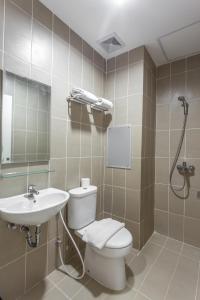 a bathroom with a toilet and a sink and a shower at Astera Hotel Bintaro in Serpong