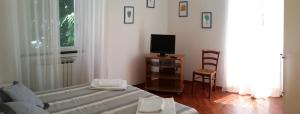 a living room with a bed and a tv at Da Iole in La Spezia