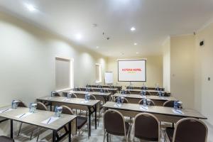 a classroom with tables and chairs and a screen at Astera Hotel Bintaro in Serpong