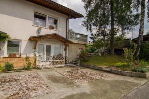 a white house with a balcony and a yard at Apartments Olga in Bled