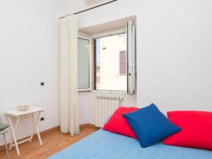 ローマにあるMatilda's Apartmentのベッドルーム1室(赤と青の枕が備わるベッド1台付)