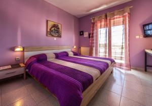 Dormitorio púrpura con cama grande con sábanas púrpuras en Apartments Borghese, en Pula