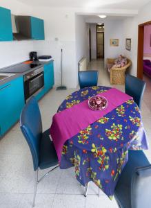 a kitchen with a table with a purple table cloth at Apartments Borghese in Pula