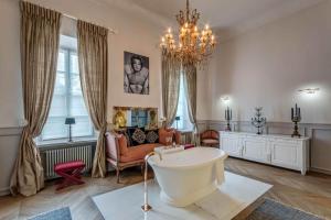 uma ampla sala de estar com uma banheira e um lustre em Hotel & Spa Pałac Mała Wieś em Mała Wieś