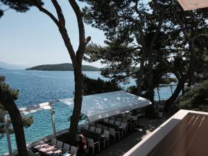 a swimming pool with a table and chairs next to the water at Rondina House in Korčula