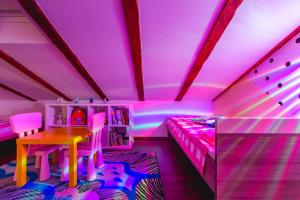 a bedroom with a table and a bed with purple lights at Apartment Lena in Rijeka