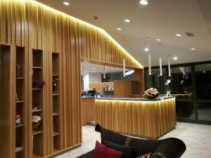 a hotel lobby with a bar with wooden walls at Hotel Caracas in Lignano Sabbiadoro