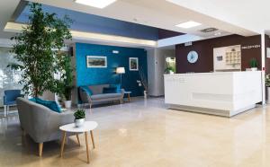 een lobby met blauwe muren en stoelen en een tafel bij Hotel Hermes Budva in Budva