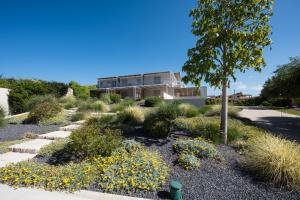 a garden with yellow flowers in front of a building at La Scibina in Marina di Ragusa