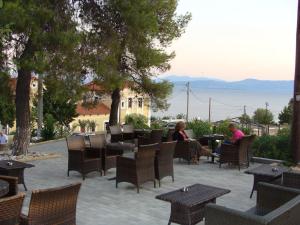 two people sitting at a patio with tables and chairs at Rodon in Loutra Edipsou