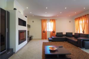 sala de estar con sofá y TV en Akivillas Pera Relax II, en Alcantarilha