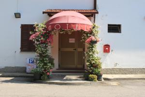 un edificio con un paraguas y flores delante de él en Hotel Rivazza en Imola