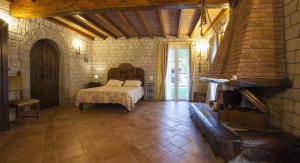 a bedroom with a bed and a brick wall at Cà di Gatti Guesthouse in Ne