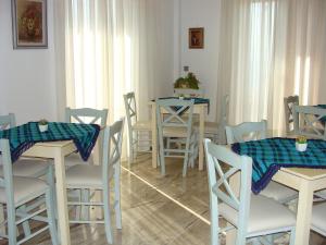 a dining room with white chairs and tables with blue table cloth at Rodon in Loutra Edipsou
