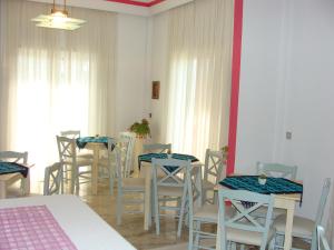 a room with tables and chairs and a room with windows at Rodon in Loutra Edipsou