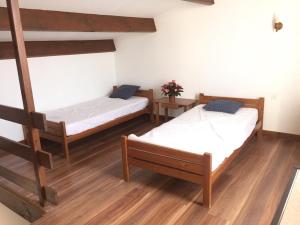 two beds in a room with wooden floors at Alizés in Saint-Denis-dʼOléron +66 photos