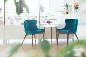 duas cadeiras e uma mesa num quarto em Hotel Hermes Budva em Budva