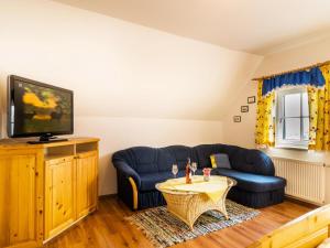 a living room with two blue couches and a tv at Landhof Steinbäck in Sankt Stefan ob Stainz