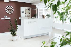 un mostrador blanco en una tienda con plantas en Hotel Hermes Budva en Budva